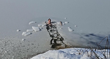 Uludağ'ın buz tutan göllerine girerek soğuk suyun keyfini çıkarıyor